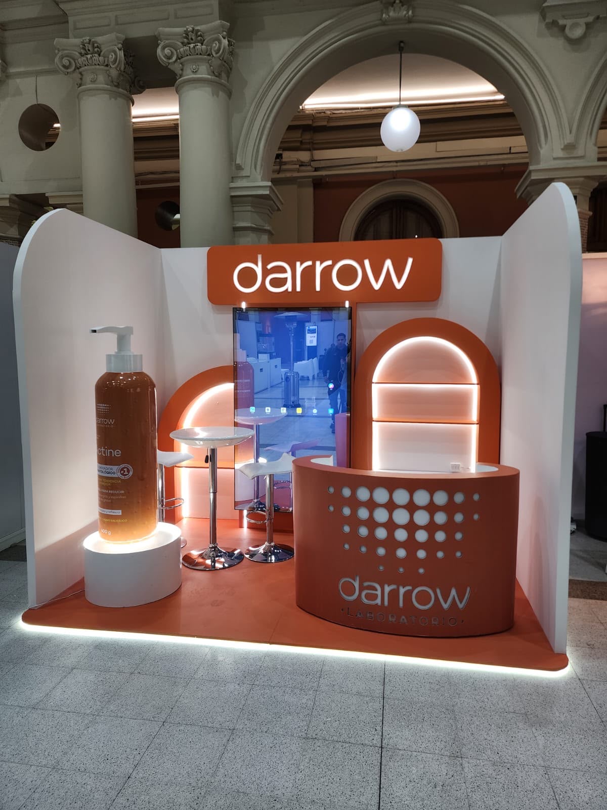 Espacio comercial para evento con mobiliario y letrero iluminado